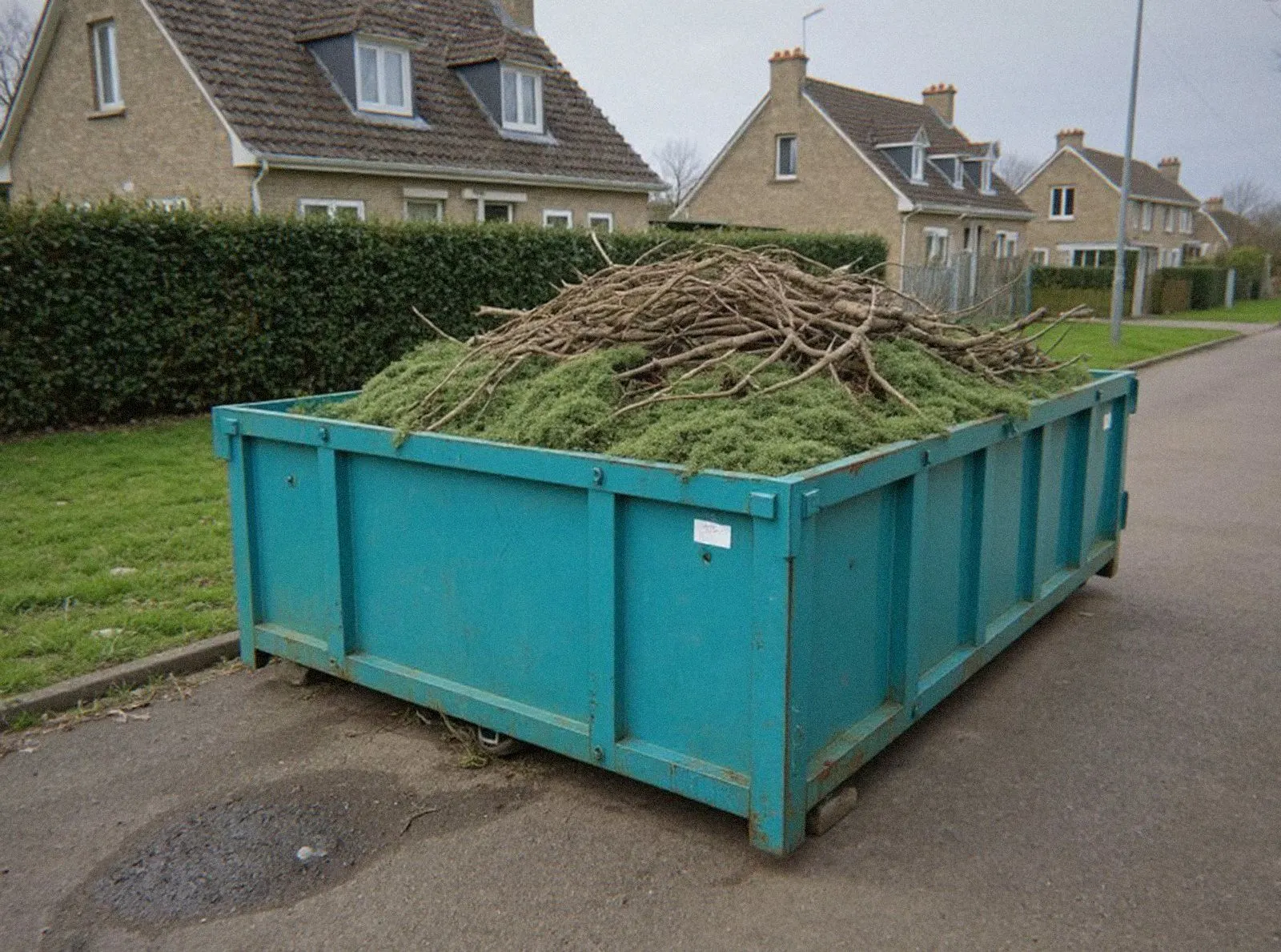 Benne remplie de branches et de tailles de haies devant une maison de Haguenau