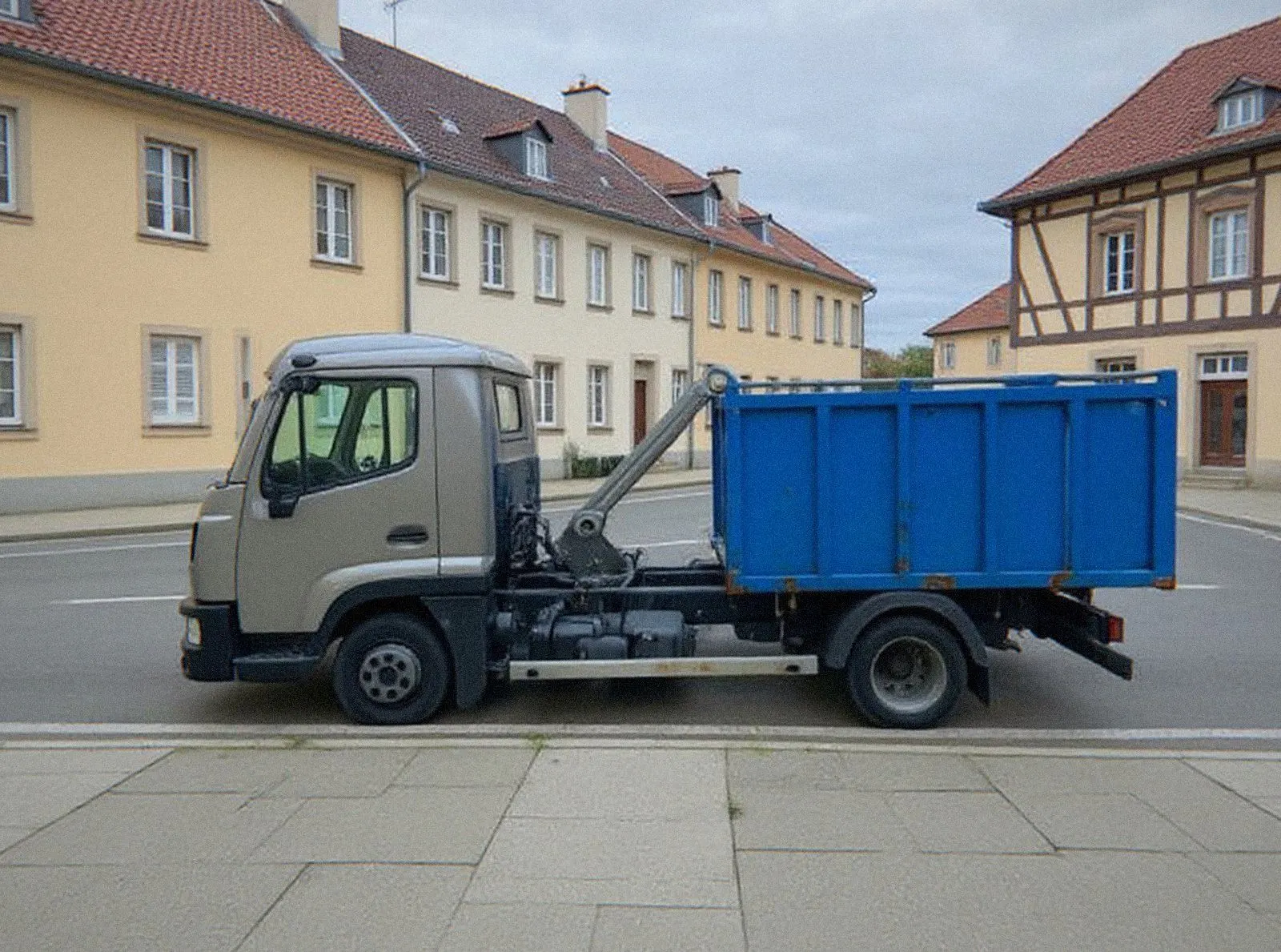 Camion ampliroll de HAG Benne garé dans une rue de Haguenau avec une benne bleue chargée