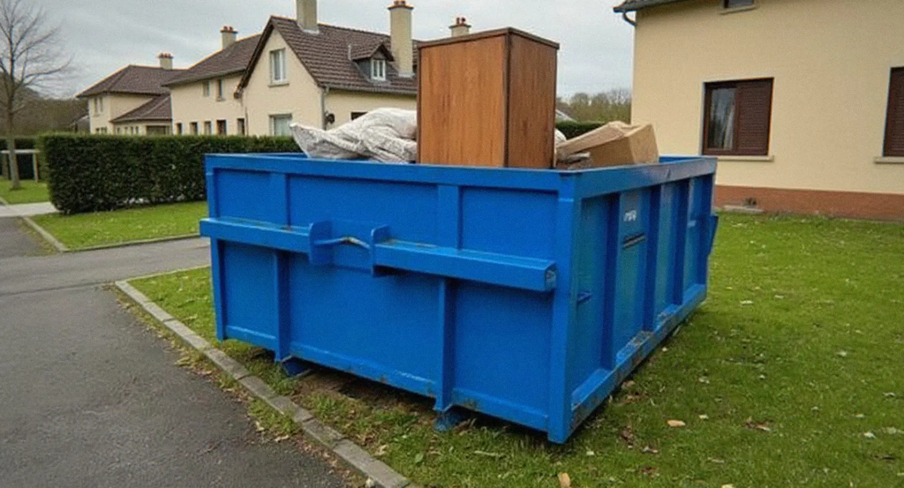 Benne bleue remplie de meubles et de cartons après le vidage d'une maison à Haguenau, location de benne pour particuliers